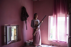 Ozlem, 17 is posing for the photographer with his gun, vest and cartridge from Oymatas village which is known as the little Hasankeyf. It's been said in old stories that Adam and Eve were here in this district. They use their gun to protect their houses and cattles. Oymatas-Turkey, July 2019.