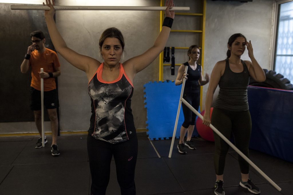 Young people while exercising in a private fitness club in Iran. Due to Iranian Islamic rules, girls and boys are not allowed to workout together in public fitness clubs. October 2018-Tehran.